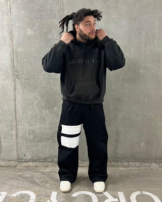 Person wearing kayoz naruto shinobi cargos with white stripes in front of a concrete wall.